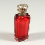A VICTORIAN FACET CUT RUBY GLASS SCENT BOTTLE AND STOPPER with silver cap. 6cms long.