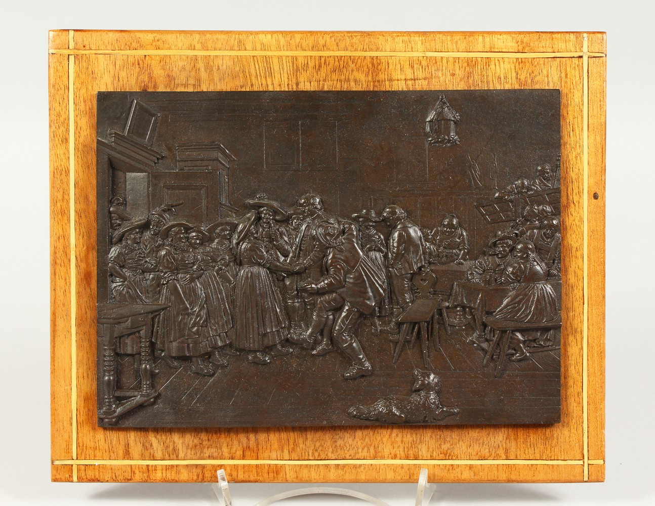 A CONTINENTAL RELIEF CAST BRONZE PLAQUE, depicting an interior scene with figures. 21cms wide x