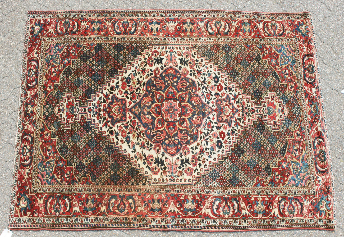 AN OLD BAKHTIARI PERSIAN RUG 1920'S-1930'S, with a large diamond shaped motif and many other motifs.