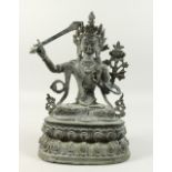 A LARGE BRONZED GOD sitting cross legged on an oval base. 14ins high.