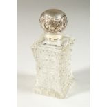 A VICTORIAN SHAPED CUT GLASS SCENT BOTTLE AND STOPPER with screw off repousse silver top. London