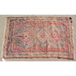 A LARGE OLD PERSIAN SHIRAZ RUG with three main diamond shaped motifs. 7ft 4ins x 4ft 8ins.