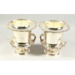 A PAIR OF TWO HANDLED CAMPAGNA URN SHAPED VASES with gadrooned edge on circular bases. 10ins high.