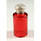 A VICTORIAN CIRCULAR RUBY GLASS SCENT BOTTLE with repousse silver screw off top. 6.5cms high (base