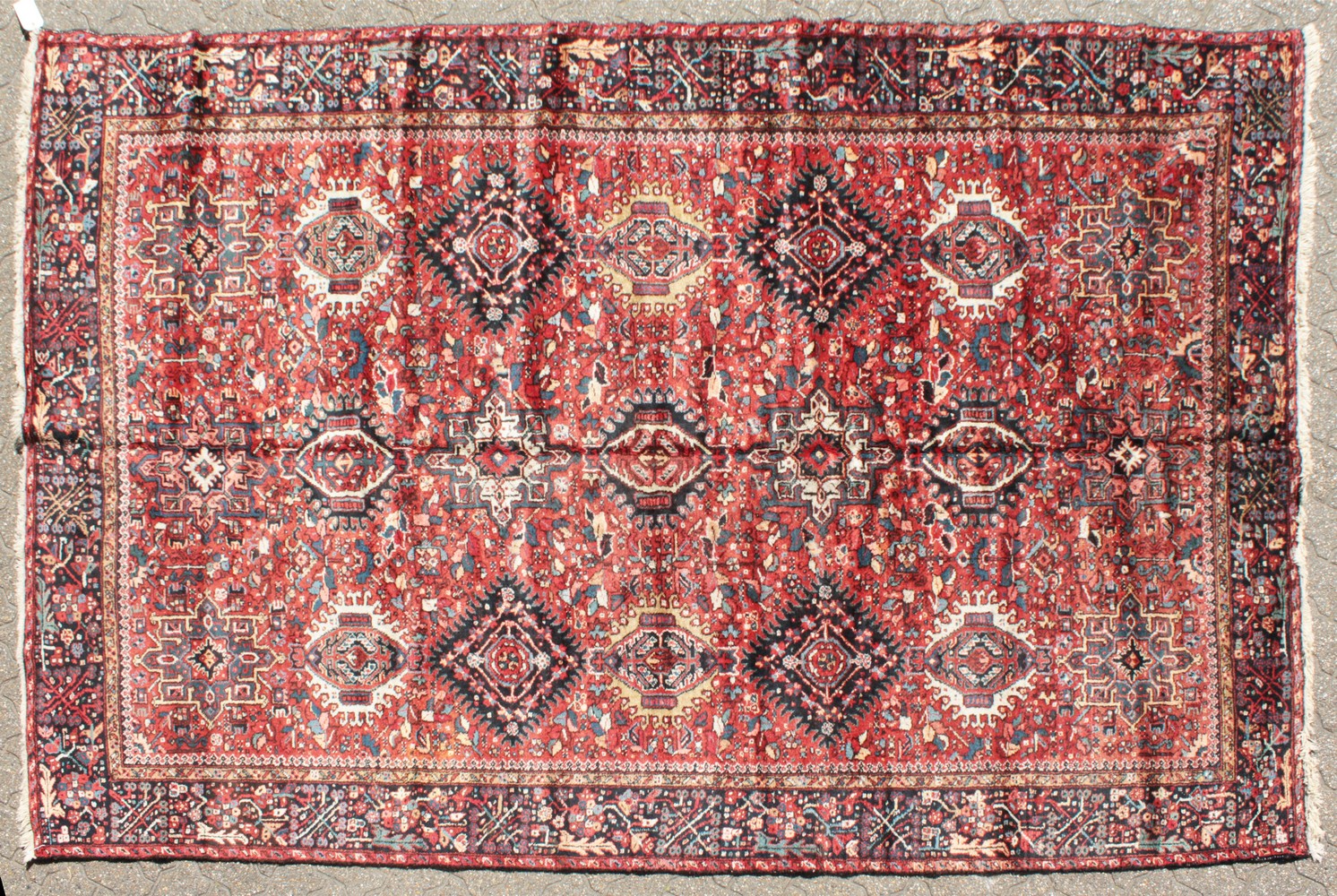 A LARGE PERSIAN KARAJA CARPET with seven central medallions in red and blue. 10ft 10ins x 7ft 4ins.