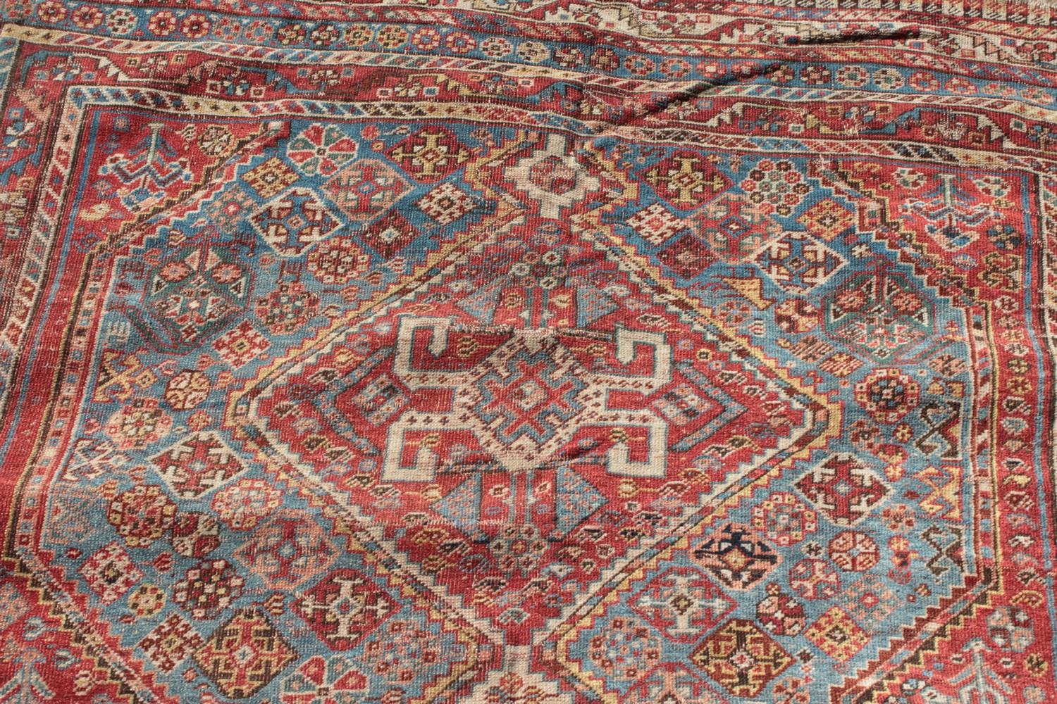 A LARGE OLD PERSIAN SHIRAZ RUG with three main diamond shaped motifs. 7ft 4ins x 4ft 8ins. - Image 5 of 10