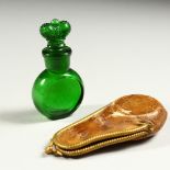 A VICTORIAN GREEN GLASS SCENT BOTTLE, the stopper as a crown, in a folding leather case. 8cms high.