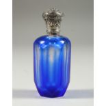 A VICTORIAN BLUE OVERLAID SCENT BOTTLE with silver top. 8cms high x 8cms long.