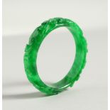 A CARVED CHINESE APPLE GREEN BANGLE.