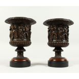 A VERY GOOD PAIR OF BRONZE CAMPAGNA VASES on black marble bases, the borders with classical figures.