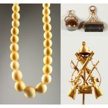 AN EARLY 20TH CENTURY IVORY BEAD NECKLACE, a gilt metal military stick pin and two fob seals.
