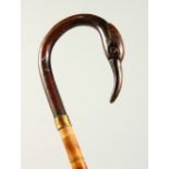 A SLENDER WALKING STICK with carved bird handle. 2ft 9ins long.