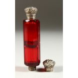 A VICTORIAN RUBY FACET CUT DOUBLE ENDED SCENT BOTTLE with repousse silver caps. 10cms long.