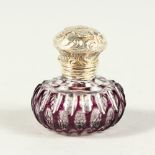 A SMALL VICTORIAN AMETHYST-TINTED GLASS SCENT BOTTLE with repousse silver top. 3.5cms diameter.