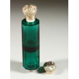 A GOOD VICTORIAN GREEN GLASS DOUBLE ENDED SCENT BOTTLE with repousse silver tops. 12.5cms long.