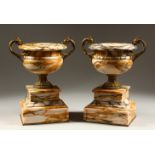 A PAIR OF CLASSICAL STYLE "SIENNA" MARBLE AND ORMOLU MOUNTED TWIN HANDLED URNS, supported on stepped