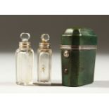 A GEORGE III PAIR OF GLASS SCENT BOTTLES AND STOPPERS in a leather case. 5cms. 50