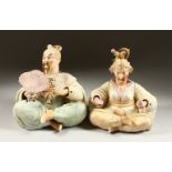 A PAIR OF 19TH CENTURY BISQUE PORCELAIN SEATED "NODDING" FIGURES of a man holding a fan and a lady