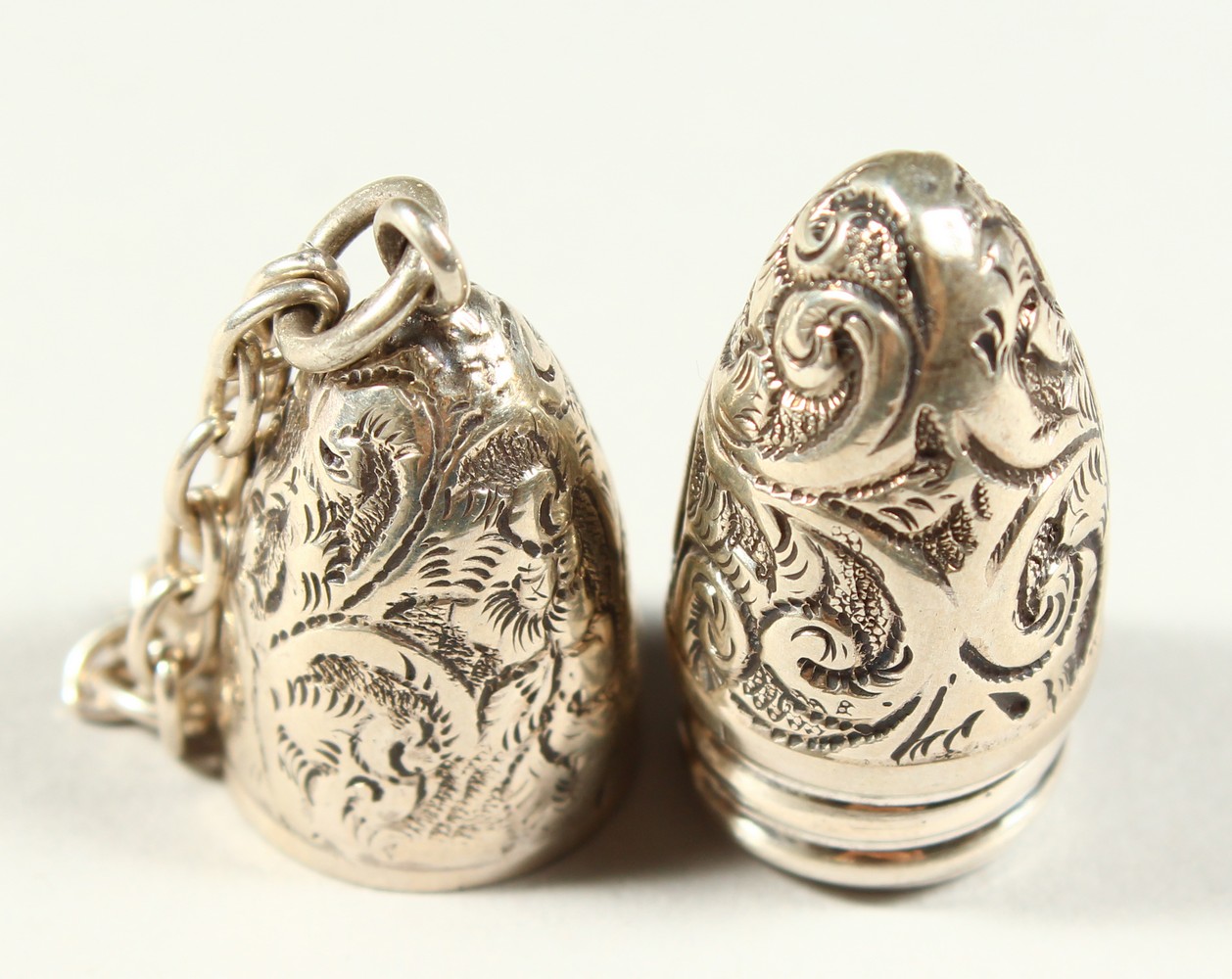 A SMALL VICTORIAN BULLET SHAPED SILVER SCENT BOTTLE with engraved decoration on a chain. 4.5cms - Image 3 of 6