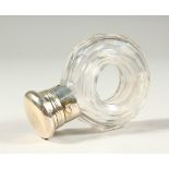 AN EDWARDIAN GLASS SCENT BOTTLE with a hole in the centre, with plated cap. 5.5cms diameter x 7.5cms