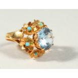 AN 18CT GOLD BLUE STONE AND TURQUOISE RING.