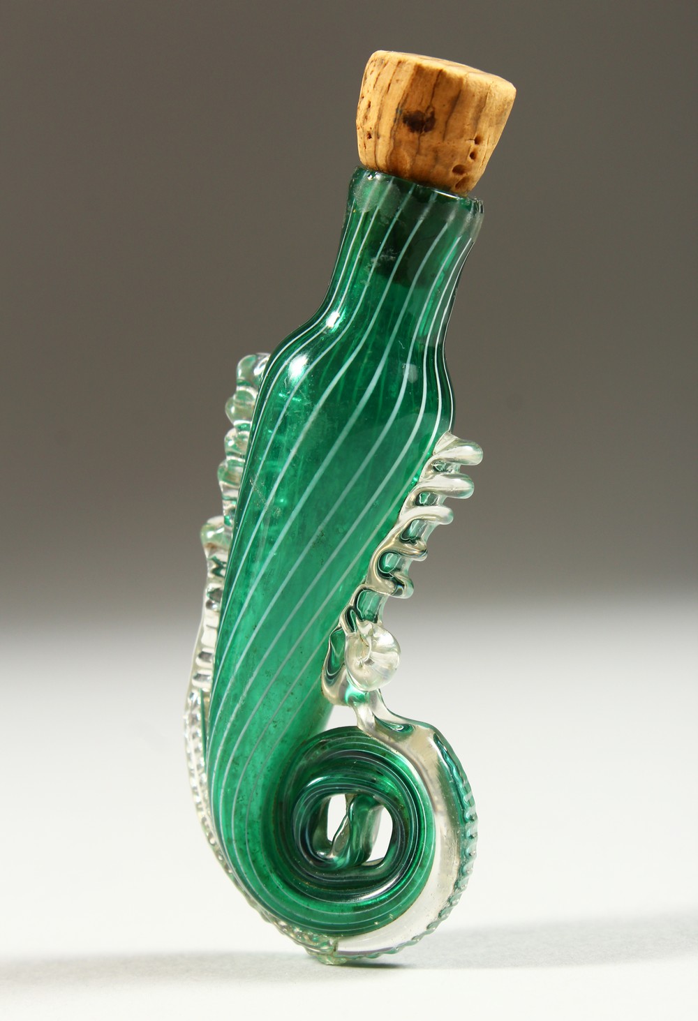 AN ITALIAN GREEN GLASS SPIRAL SHAPED SCENT BOTTLE with cork stopper. 7.5cms long.