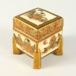 A GOOD SATSUMA SQUARE BOX AND COVER with panels of figures, on four legs. 2.75ins.