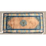 A CHINESE WOOL RUG with central motif and patterned border. 4ft 7ins x 2ft 3ins.