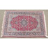 A FINE PERSIAN SILK AND WOOL ISFAHAN CARPET with allover red and blue design.