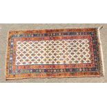 A KURDISH PERSIAN TRIBAL RUG with a key row of motifs on a white ground within a red and blue three
