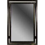 PIERRE VANDEL,PARIS, A POLISH BLACK METAL FRAMED WALL MIRROR with gilt metal decoration. 89cms