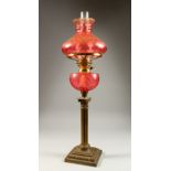 A GOOD VICTORIAN BRASS AND CRANBERRY GLASS CORINTHIAN COLUMN OIL LAMP, RESERVOIR AND SHADE.