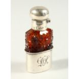 A 19TH CENTURY CONTINENTAL CUT AMBER-COLOURED GLASS SCENT FLASK AND STOPPER with silver cap and cup.