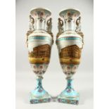 A PAIR OF TWO HANDLED URN SHAPED VASES painted with a continuous scene of a city centre with