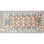 A CHINESE WOOL RUG with central motifs and blue and green border. 4ft 8ins x 4ft 3ins.