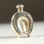 A HORSESHOE SHAPED SCENT BOTTLE. Initialled C. A. 22.8.89. 5.5cms long.