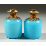 A PAIR OF 19TH CENTURY FRENCH BLUE OPALINE SCENT BOTTLES with gilt mounts, the tops with scenes of