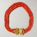 A SUPERB THREE ROW CORAL NECKLACE with gold clasp. 162 grams.