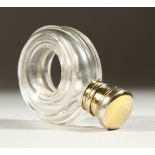 AN EDWARDIAN GLASS SCENT BOTTLE with a hole in the centre, with silver cap and plain glass