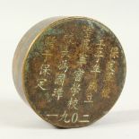 A CHINESE BRONZE CIRCULAR BOX AND COVER engraved with calligraphy. 3ins diameter.