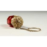A SMALL VICTORIAN FACET CUT ACORN SHAPED SCENT BOTTLE with repousse silver gilt top and chain.