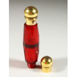 A VICTORIAN FACET CUT RUBY GLASS DOUBLE ENDED SCENT BOTTLE with gilt tops. 13cms long.