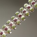 A SILVER, PERIDOT AND TOURMALINE THREE ROW BRACELET, boxed.