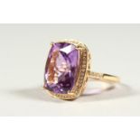 A 14k YELLOW GOLD AND DIAMOND RING set with a cushion cut purple amethyst.