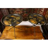 A PAIR OF CIRCULAR TOLEWARE TABLES on folding stands. 1ft 7ins diameter.