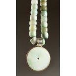 A GOOD HEAVY JADE NECKLACE with circular pendant.