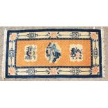 A CHINESE WOOL RUG with three main motifs with blue and green border. 4ft 7ins x 2ft 3ins.