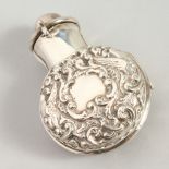 A GOOD VICTORIAN CIRCULAR GLASS SCENT BOTTLE AND STOPPER in a folding silver case repousse with