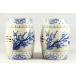 A PAIR OF CHINESE BLUE AND WHITE BARREL SEATS with almond blossom design. 1ft 6ins high.