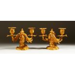A PAIR OF SMALL ORMOLU TWIN BRANCH CANDELABRA in the Rococo style. 14cms high.